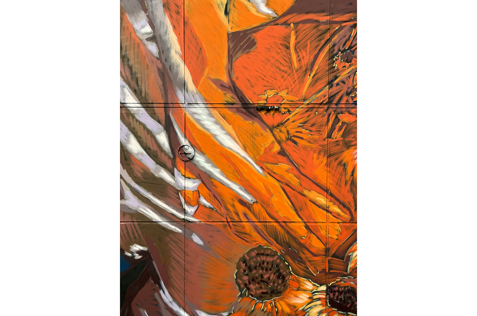 Fresque murale à Barcelone qui représente deux corps enlacés avec des fleurs autour dans des couleurs orange et bleu.