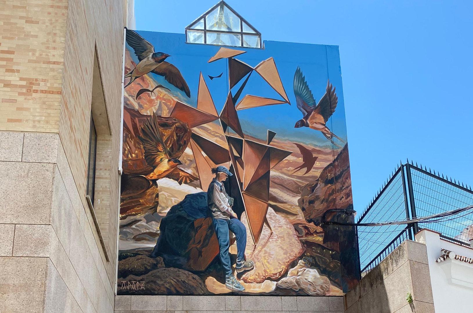 Une fresque murale à Baena dans la région de Cordoue en Espagne. Elle représente un personnage entouré d'oiseaux.