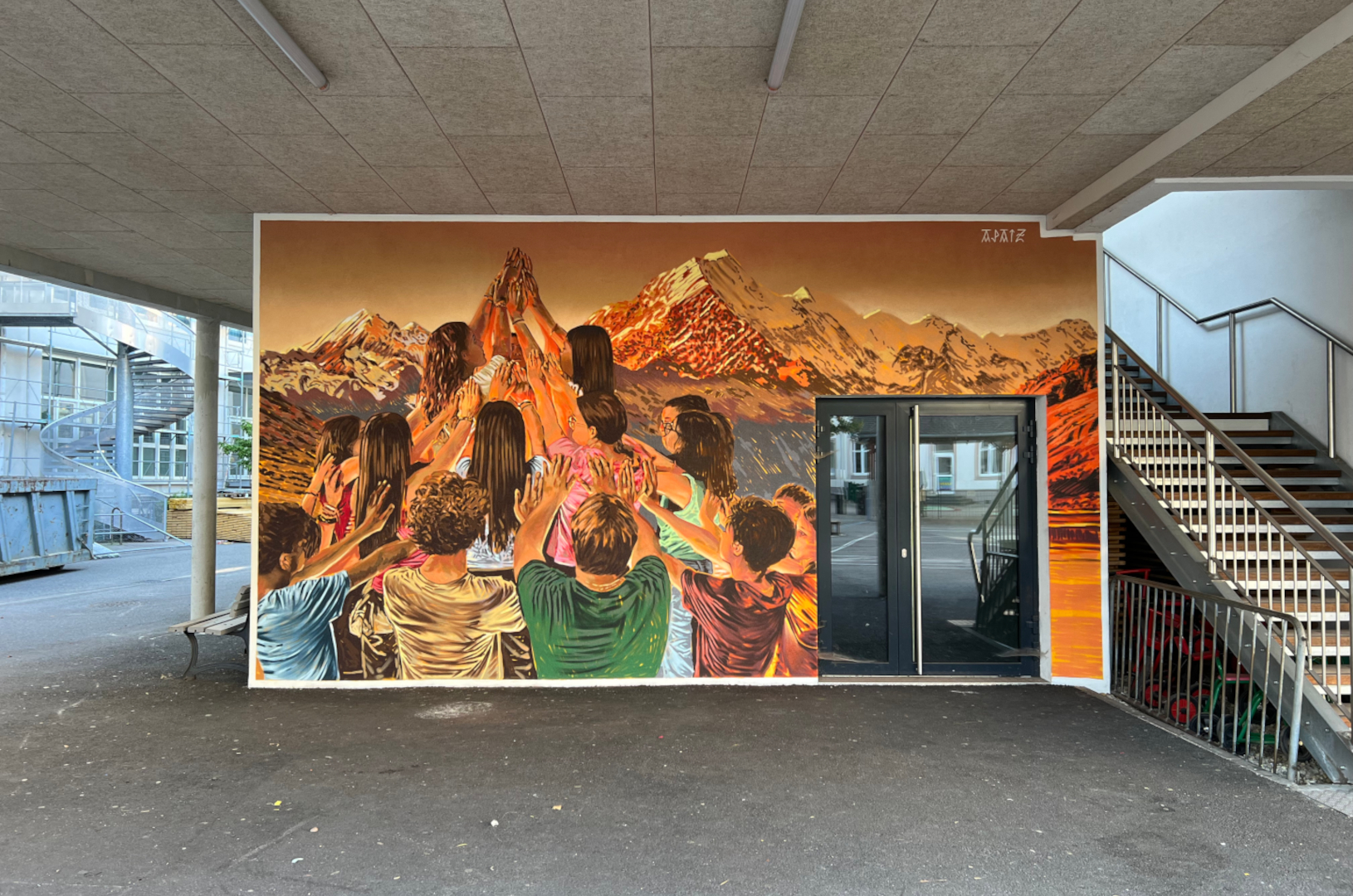 Fresque murale réalisée par APAIZ, représentant un groupe de personnes levant les mains devant un paysage alpin