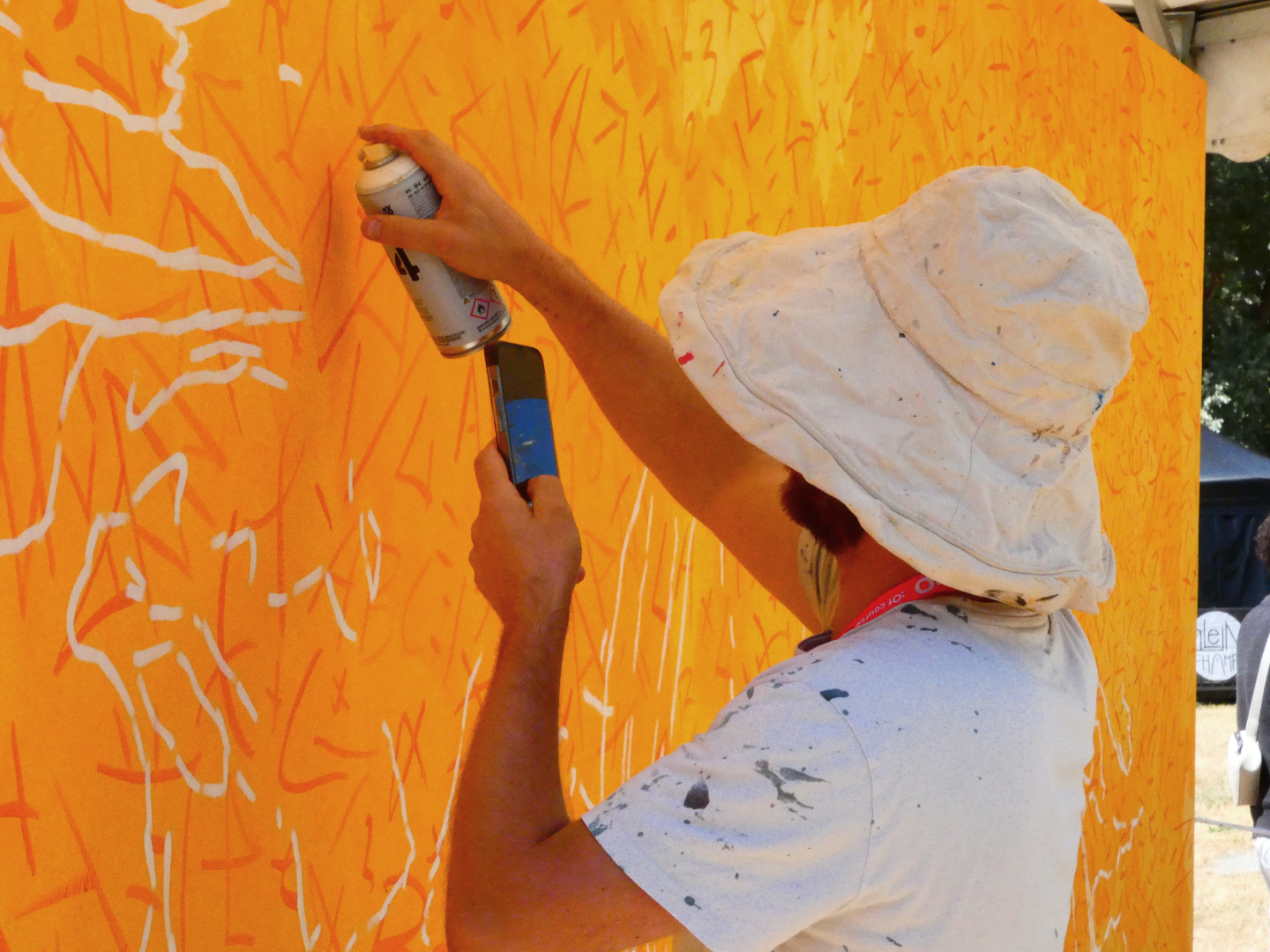 Fresque murale colorée représentant deux personnes allongées ou enlacées, peintes dans des tons vifs de bleu, rouge, orange et violet, installée en plein air dans le cadre du festival Plein Champ dans la ville du Mans.