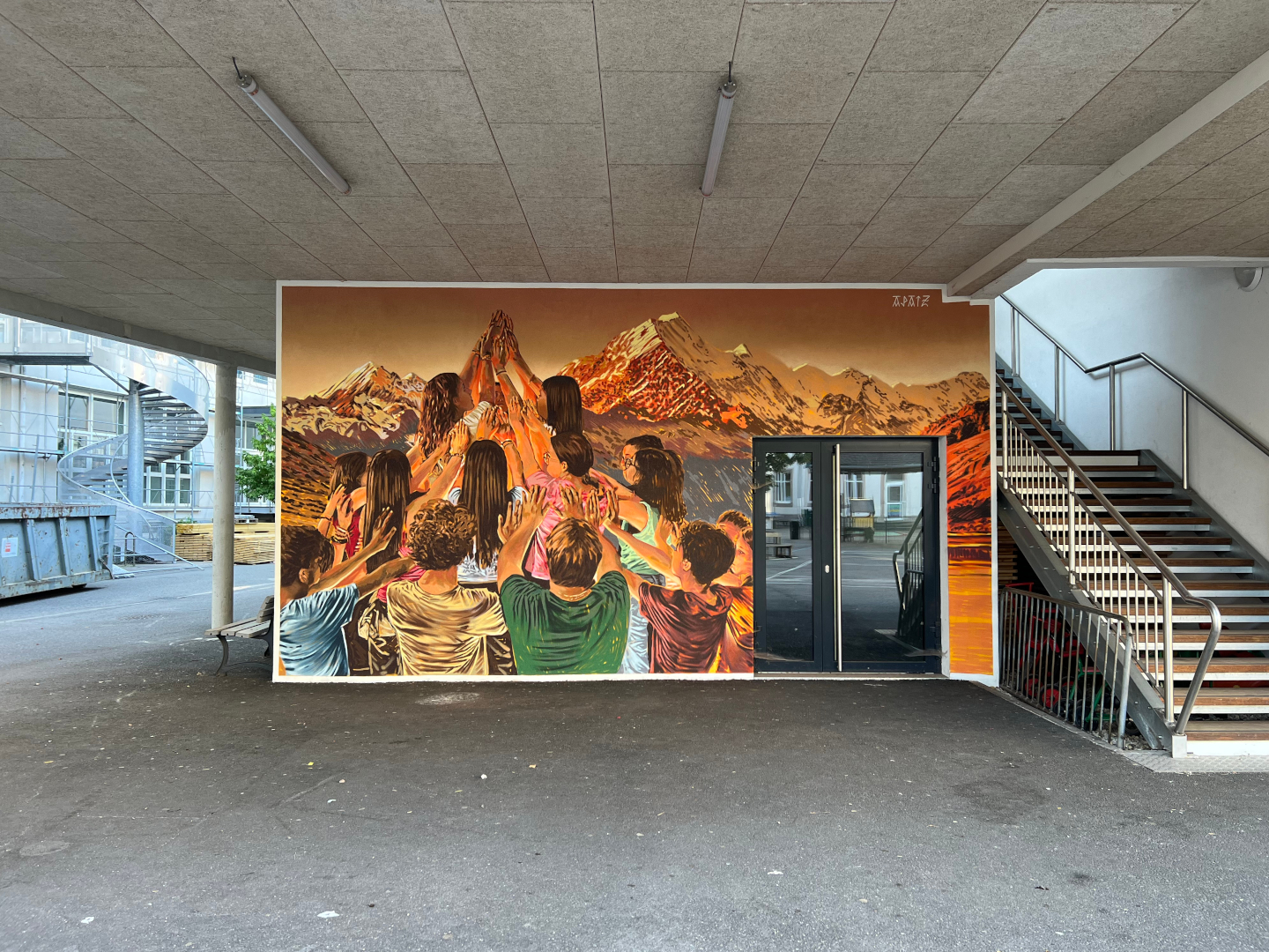 Fresque murale réalisée par APAIZ, représentant un groupe de personnes levant les mains devant un paysage alpin