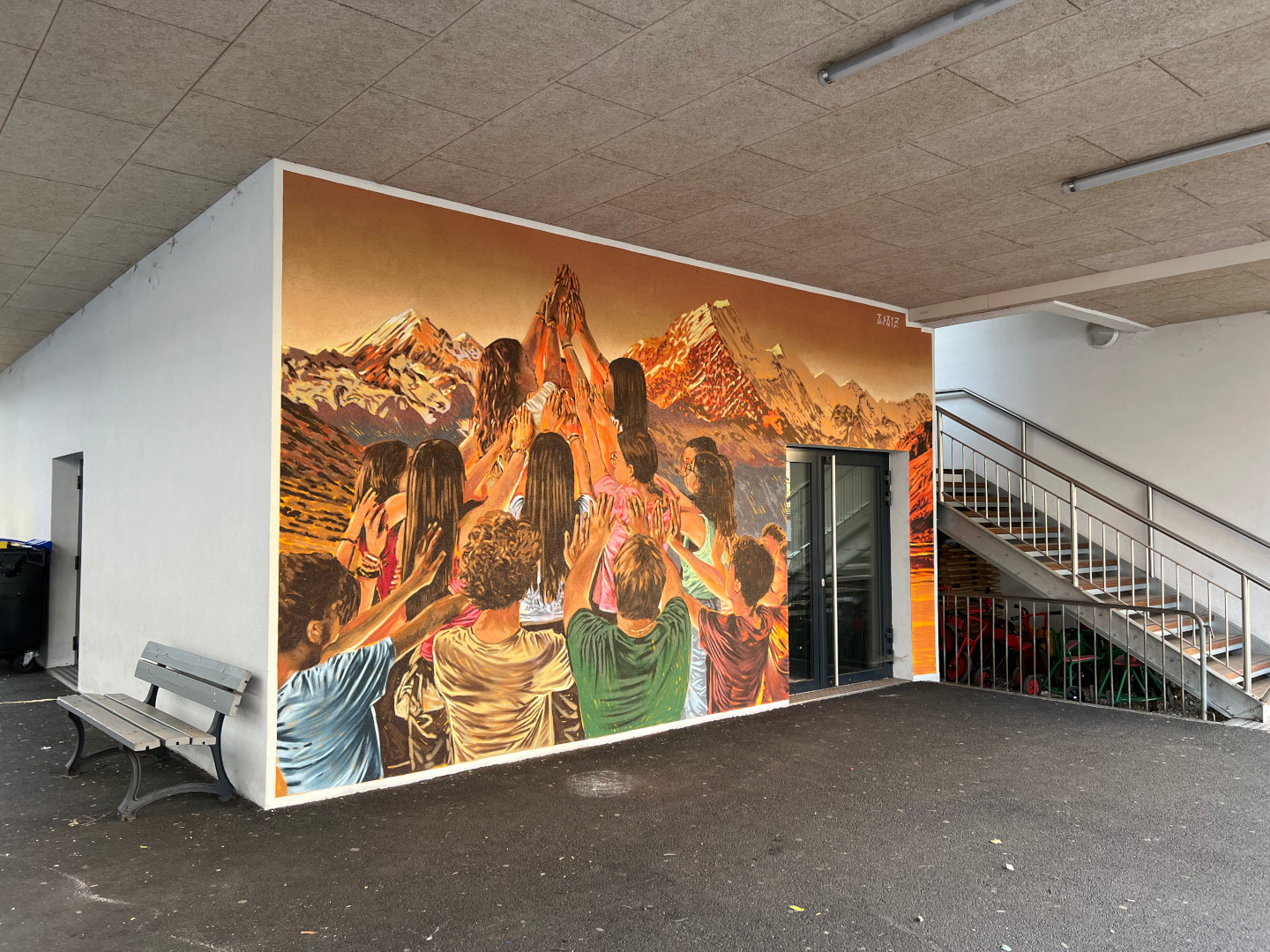 Fresque murale réalisée par APAIZ, représentant un groupe de personnes levant les mains devant un paysage alpin