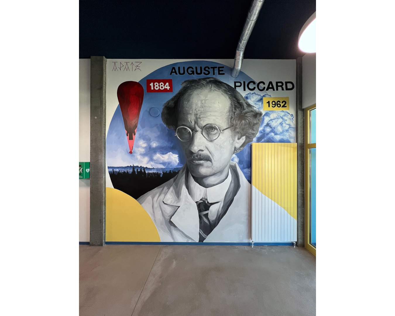 Fresque murale d’Auguste Piccard, pionnier de l’exploration de la stratosphère, entouré de son ballon, de nuages et de formes géométriques.